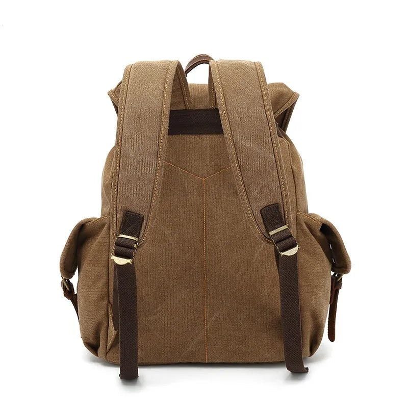 Retro canvas backpack in khaki colour with antique bronze hardware, showing front compartments and straps.