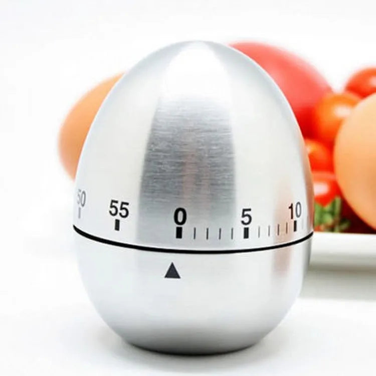 Egg-shaped stainless steel mechanical kitchen timer on a kitchen countertop.
