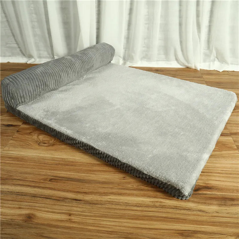 Grey corduroy pet sofa dog bed with bilateral bolsters and a non-slip cloth base on a wooden floor.