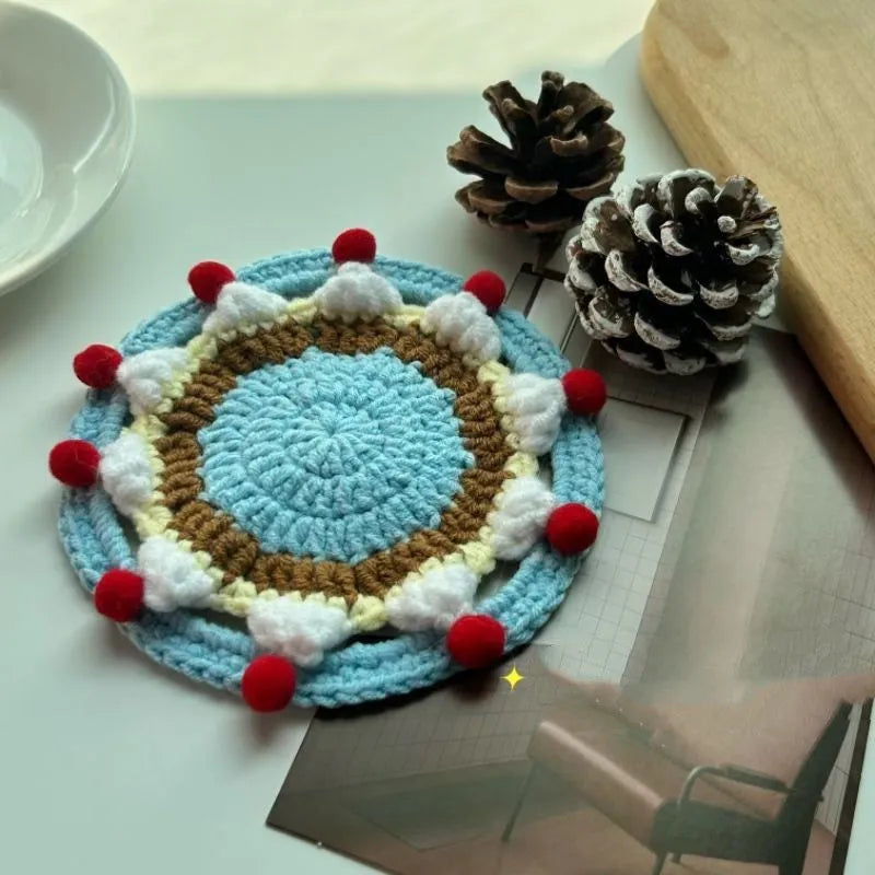 A single 9cm round wool coaster and its decorative cake-themed storage bag.