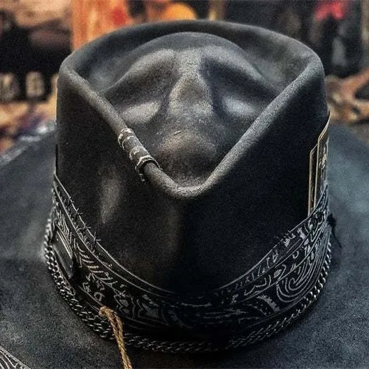 Handmade black and white skull print pointed witch hat on a wooden surface