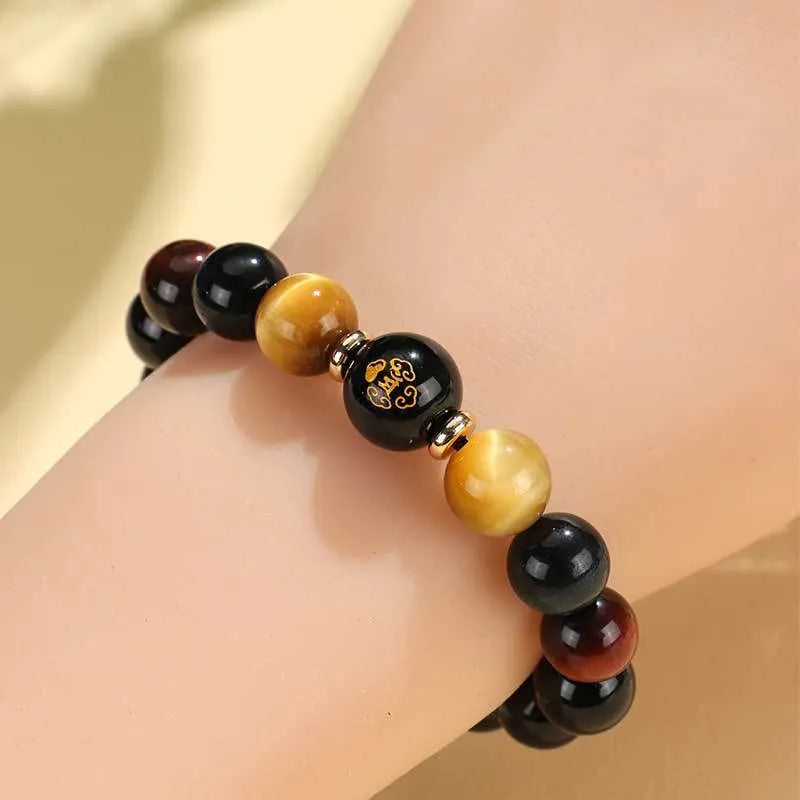 Handmade black agate beaded bracelet with gold, blue, and red tiger eye stones featuring Buddhist deity and zodiac animal motifs.