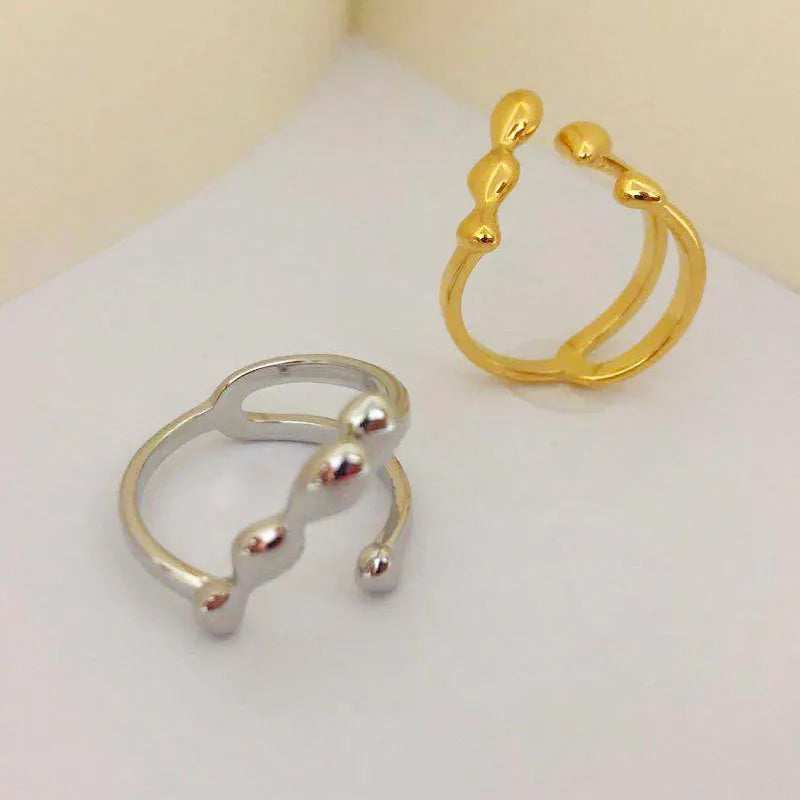 Brass ring with a spherical design on a circular band, shown in gold and silver finishes.