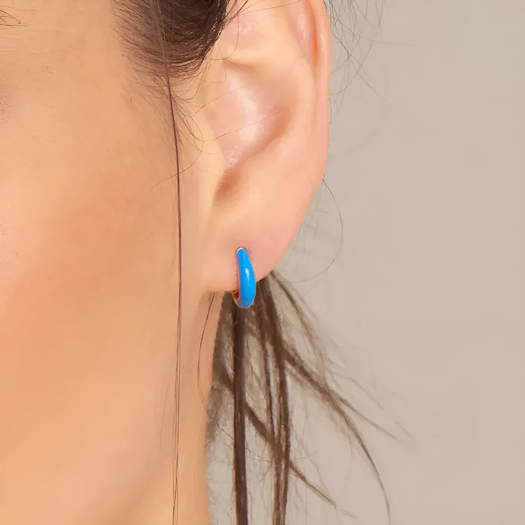 Geometric oval curved earrings for women in silver copper with a blue epoxy drip finish on a U-shaped wire.