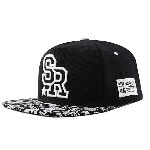 Cotton baseball cap with embroidered letters in black or white, showing adjustable strap and dome crown.