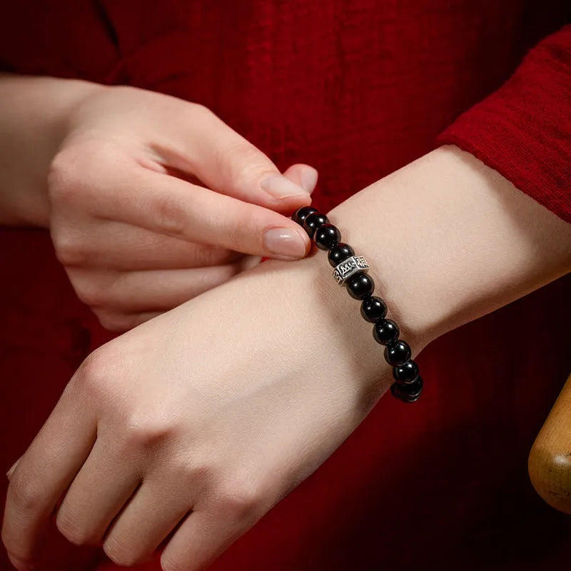 Black obsidian bracelet with 8mm beads carved with Zodiac animal and Buddhist bodhisattva designs.