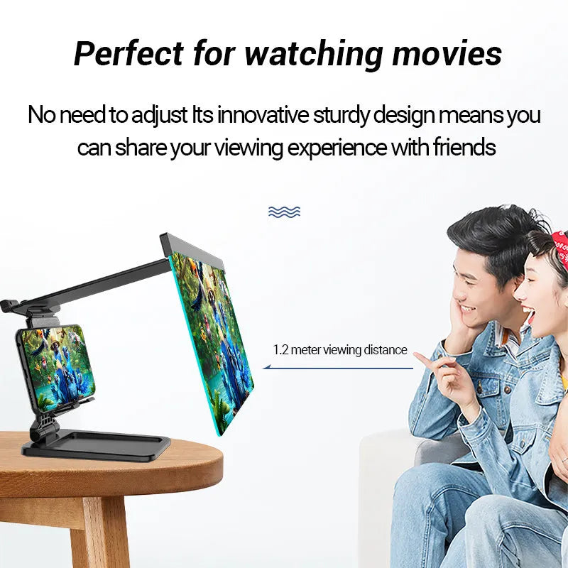 Black detachable mobile phone screen magnifier and holder set up on a desk, showing a phone displaying a magnified movie scene.