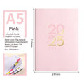 A5 2025 daily planner notebook with soft faux leather cover in multiple colours, open to show lined pages.