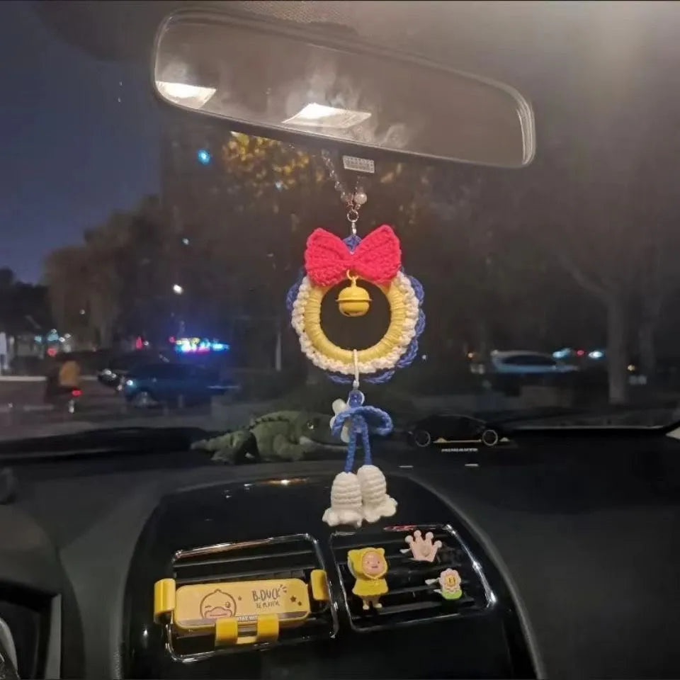 Handmade plush yarn Snow White character car hanging ornament on a clear background.