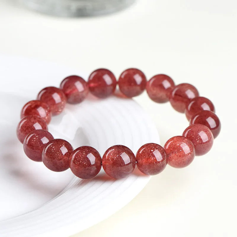 Natural cherry red strawberry quartz bracelet with geometric beads on a wrist