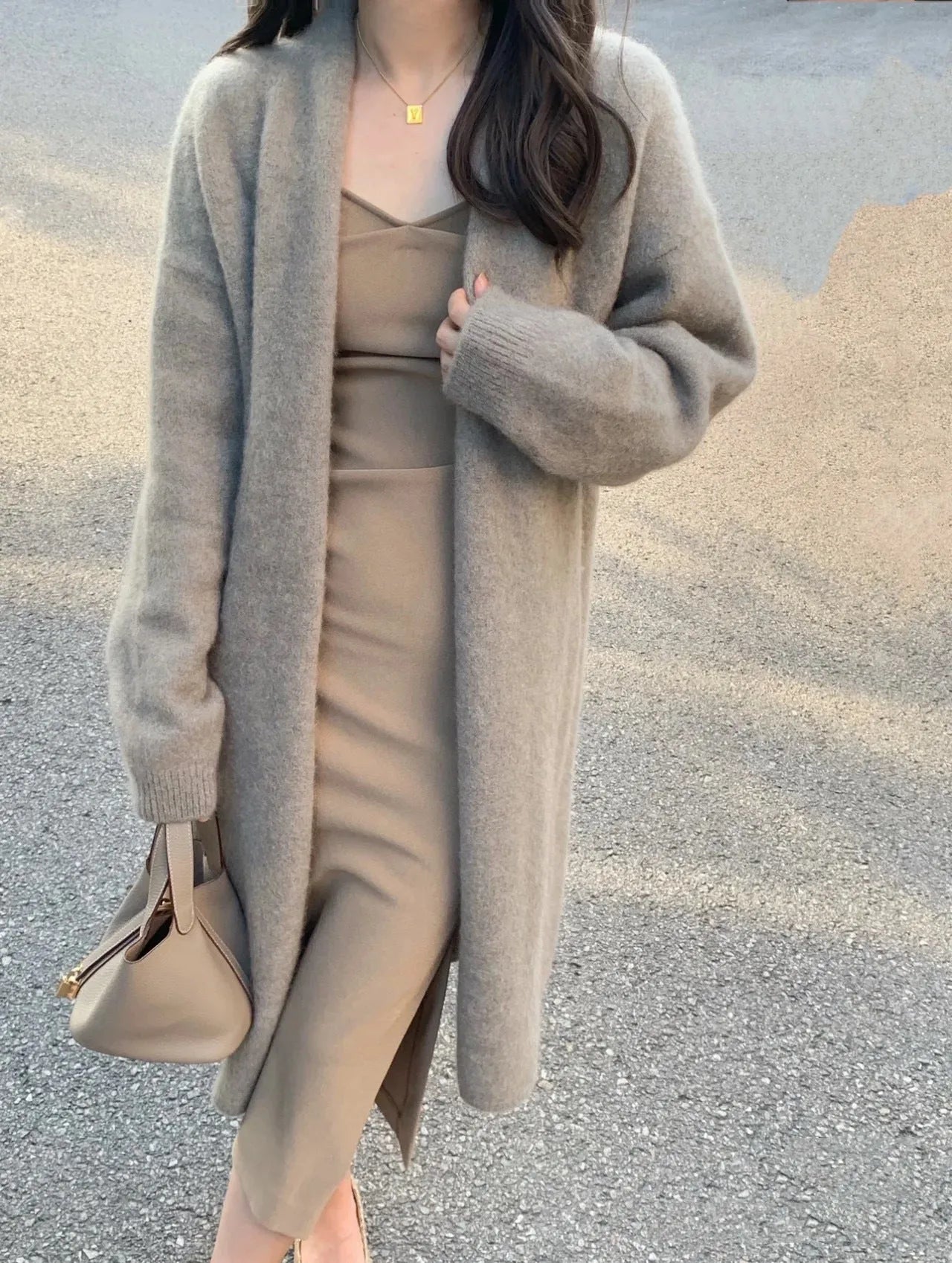 Women's khaki knitted v-neck cardigan with long sleeves on a hanger.