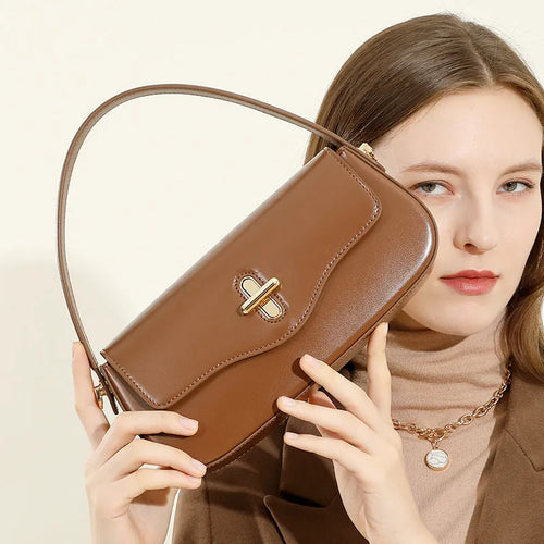 Genuine leather baguette handbag in caramel colour with clamshell design and shoulder straps