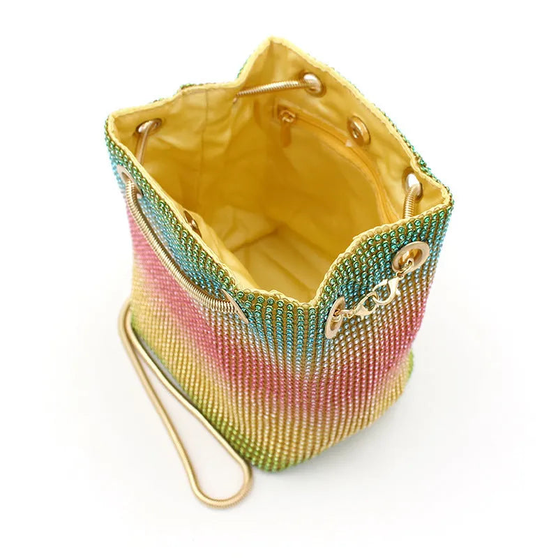 Colourful rainbow glitter rhinestone bucket bag with an adjustable metal chain strap.