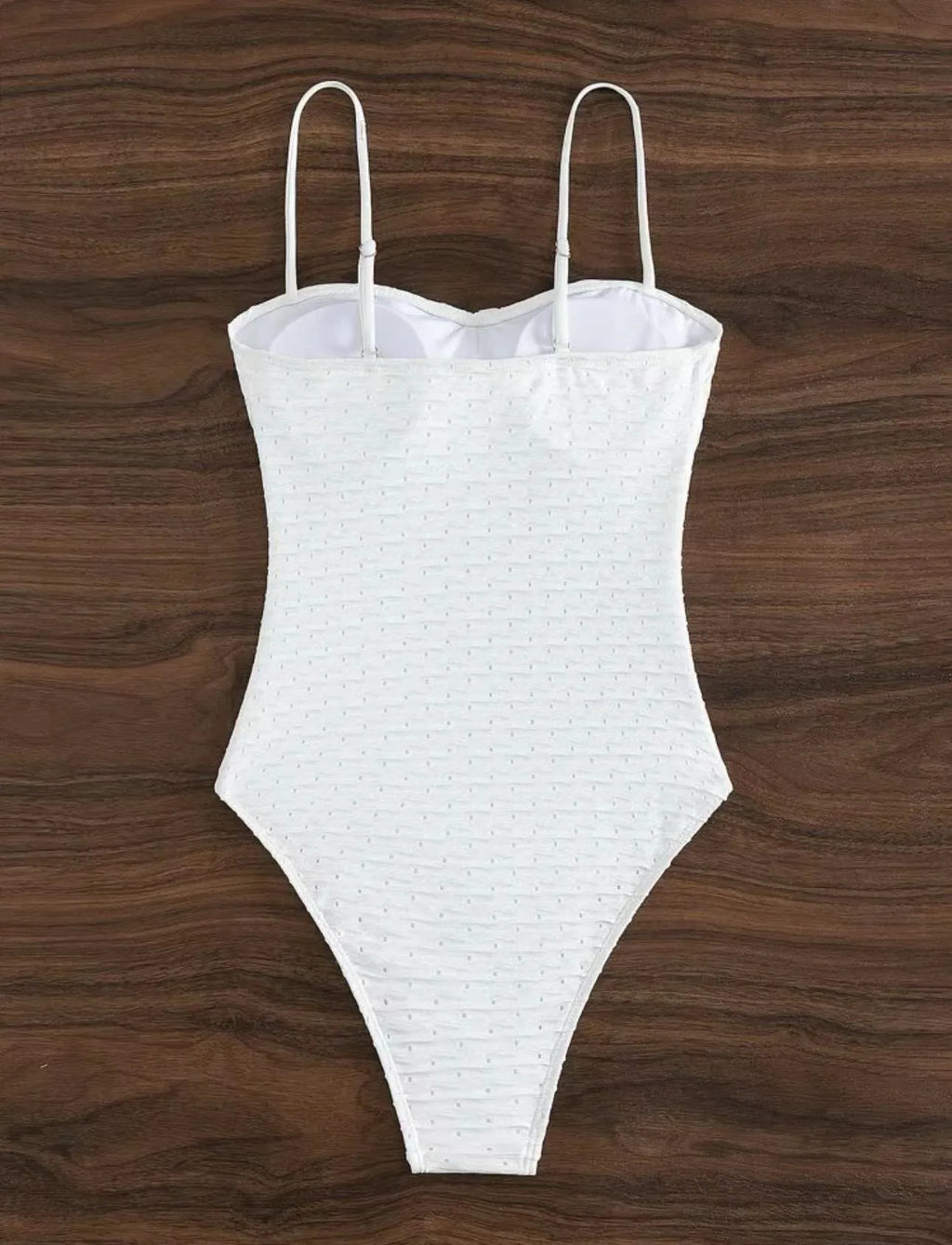 White women's one-piece swimsuit with a sling-style design made from high-elasticity polyester fabric.