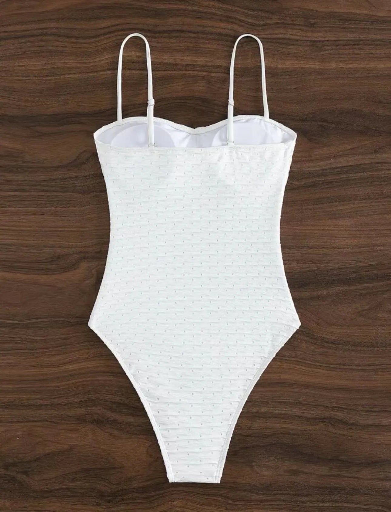 White women's one-piece swimsuit with a sling-style design made from high-elasticity polyester fabric.
