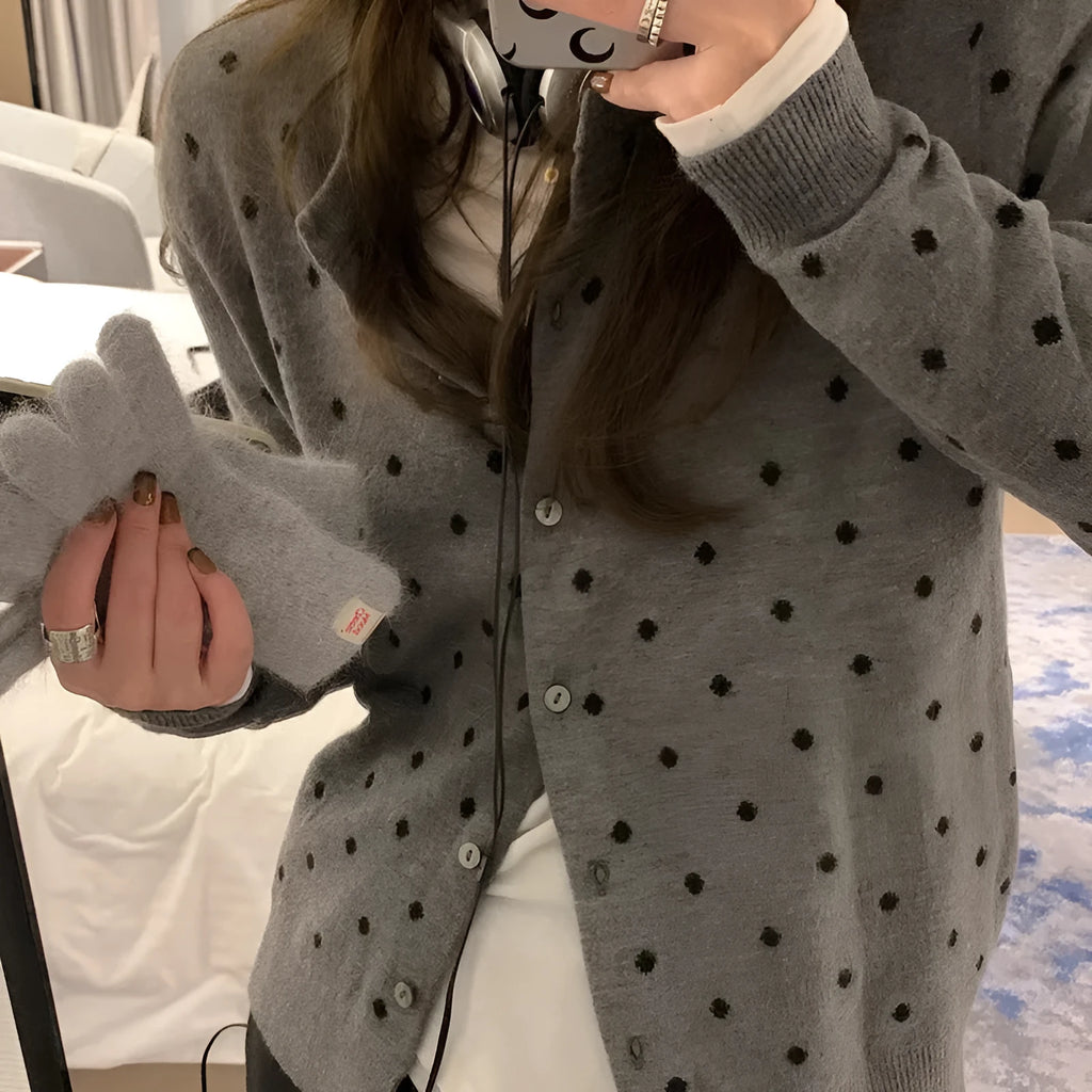 Women's grey knitted cardigan with white crochet flower embroidery on the front.