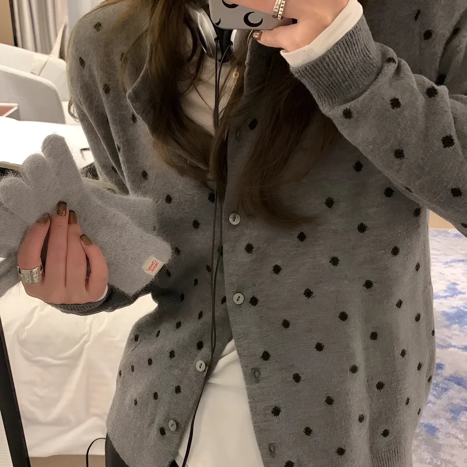 Women's grey knitted cardigan with white crochet flower embroidery on the front.