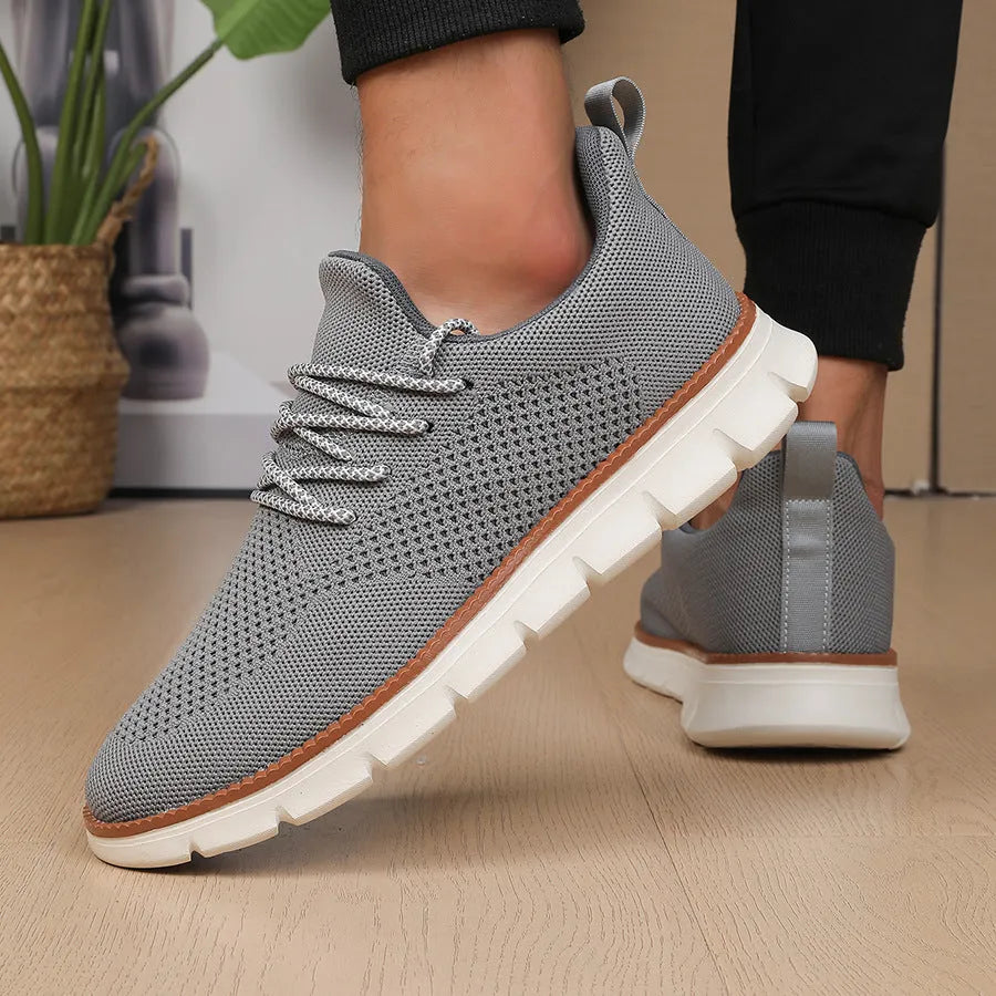 Men's grey and black low-top casual sneakers with woven mesh fabric upper and round toe.
