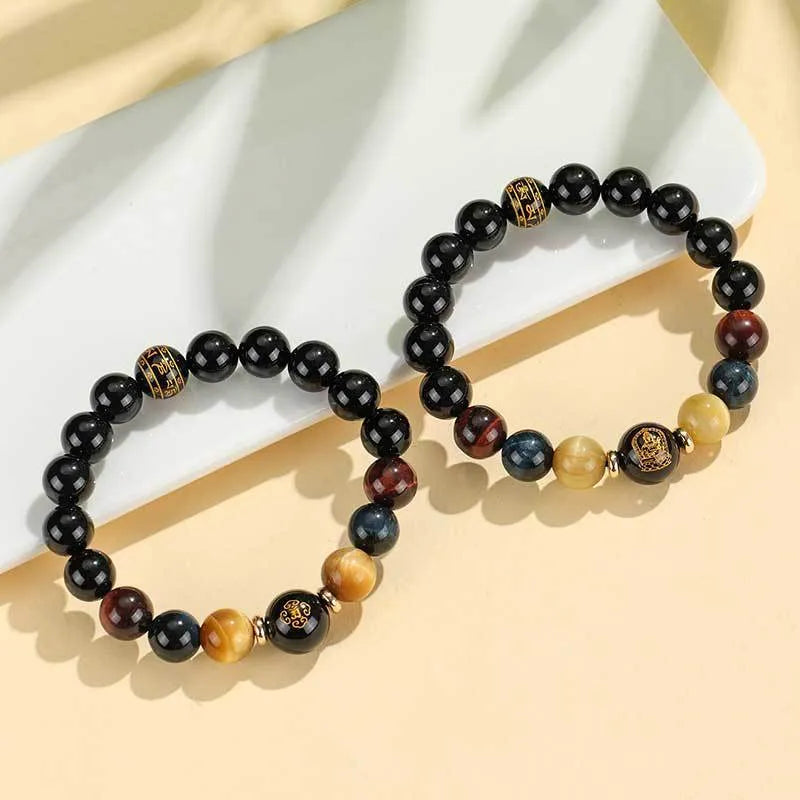 Handmade black agate beaded bracelet with gold, blue, and red tiger eye stones featuring Buddhist deity and zodiac animal motifs.