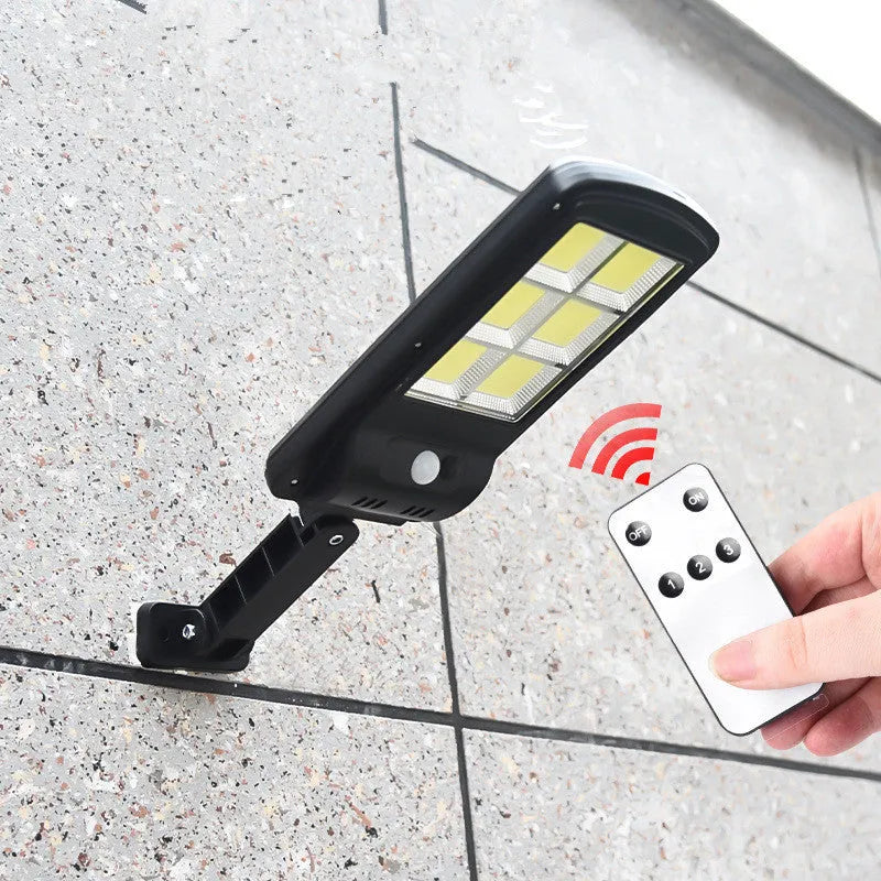 Black solar-powered outdoor wall light with motion sensor for gardens and pathways