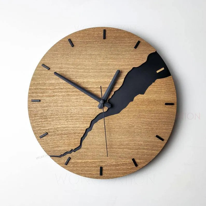Modern wooden wall clock with a cracked surface design on a plain wall.