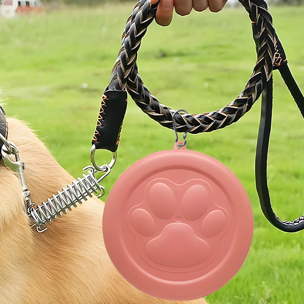 A collapsed and opened portable silicone dog bowl in a light pink colour, showing its flexible design.