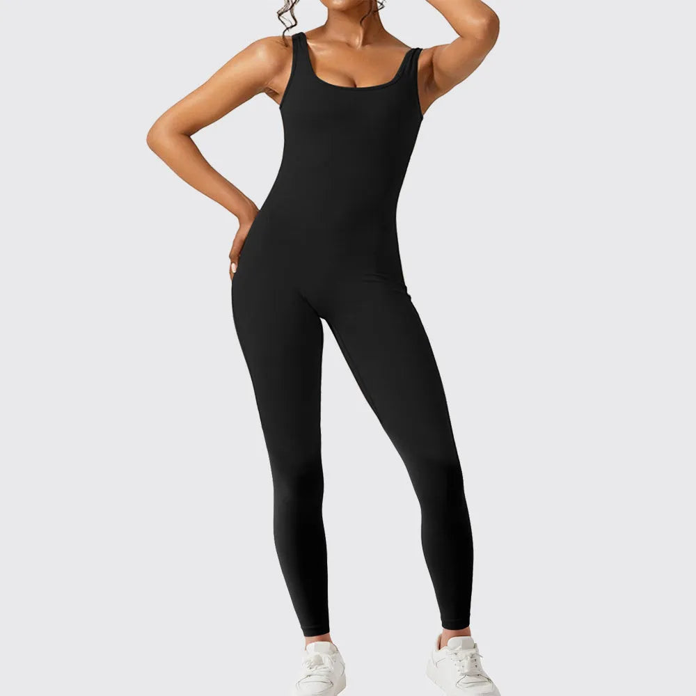 Woman wearing a sleeveless army green flare-leg jumpsuit for yoga fitness.