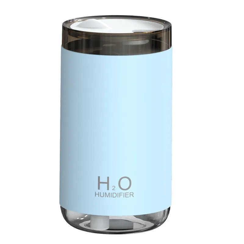 White portable USB humidifier with jellyfish mist spray and warm night light on wooden surface