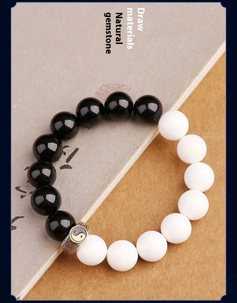 Black obsidian Taiji bracelet with white woven yin-yang symbol and mantra.