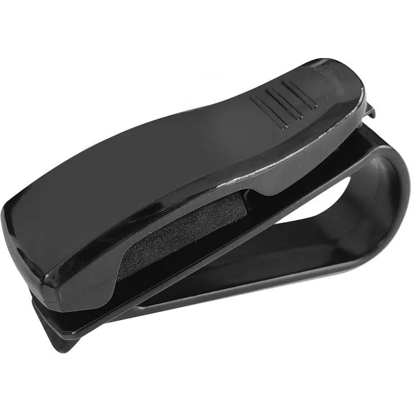 Black plastic multifunctional clip for car sunshades, holding sunglasses and a card.