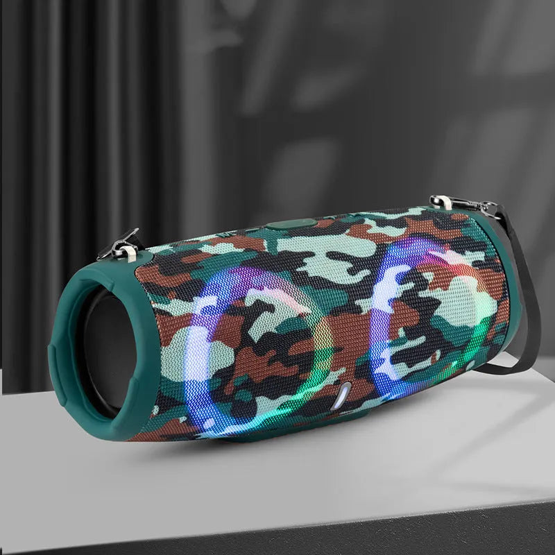 War Drum portable Bluetooth speaker with coloured RGB lights on a table outdoors.