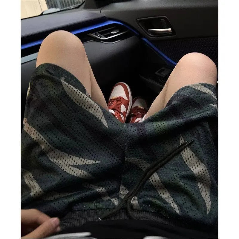 Men's straight-leg camouflage mesh shorts in a cotton-blend fabric laid flat.