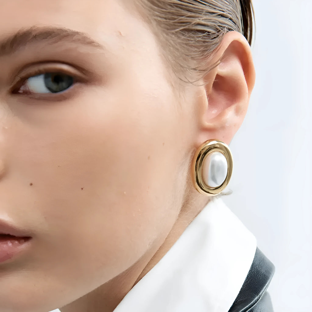 Small vintage-style pearl ear studs with a gold-tone finish on a stainless steel post.