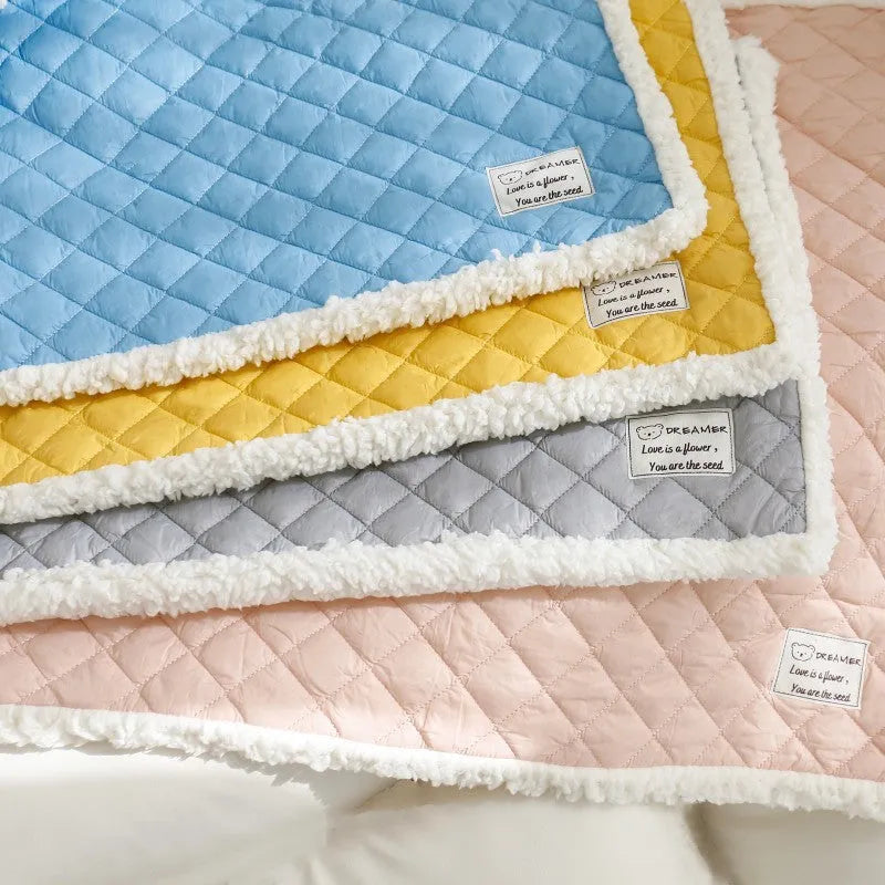 Quilted terry cloth cat blanket in blue, shown on a pet bed.