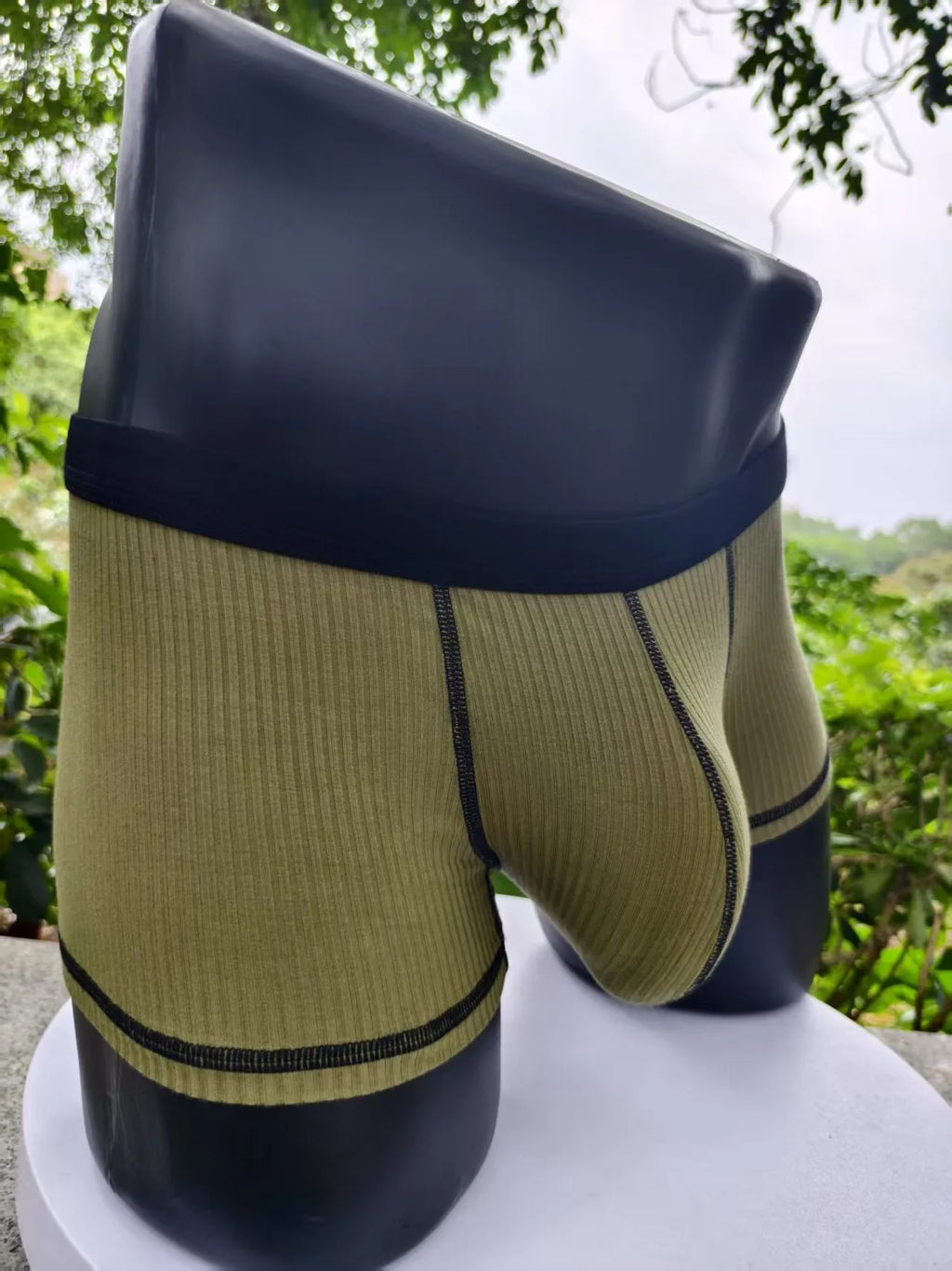 Men's solid colour boxer shorts in thin fabric, shown in army green, highlighting breathable and body-shaping design.