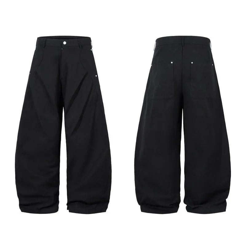 Man wearing black pleated wide-leg casual cotton trousers in a loose fit.