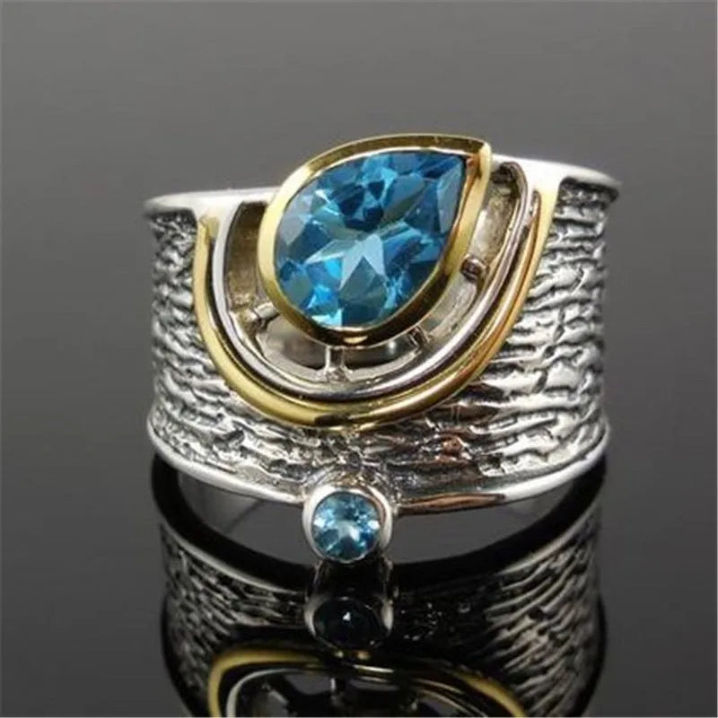 Blue zircon stone set in a drop-shaped alloy ring with Chinese style design.