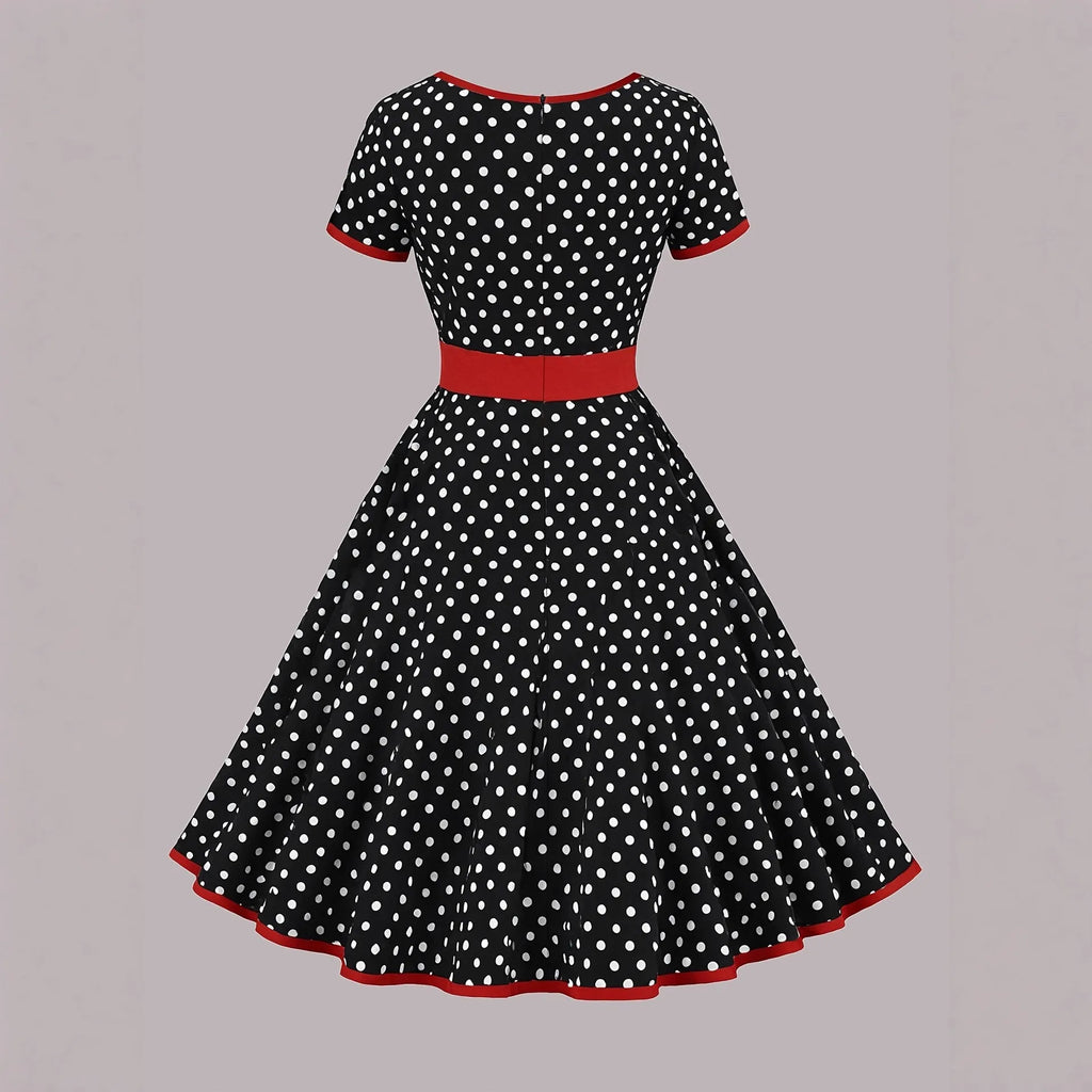 A women's polka dot pleated dress with a square collar and zip closure.