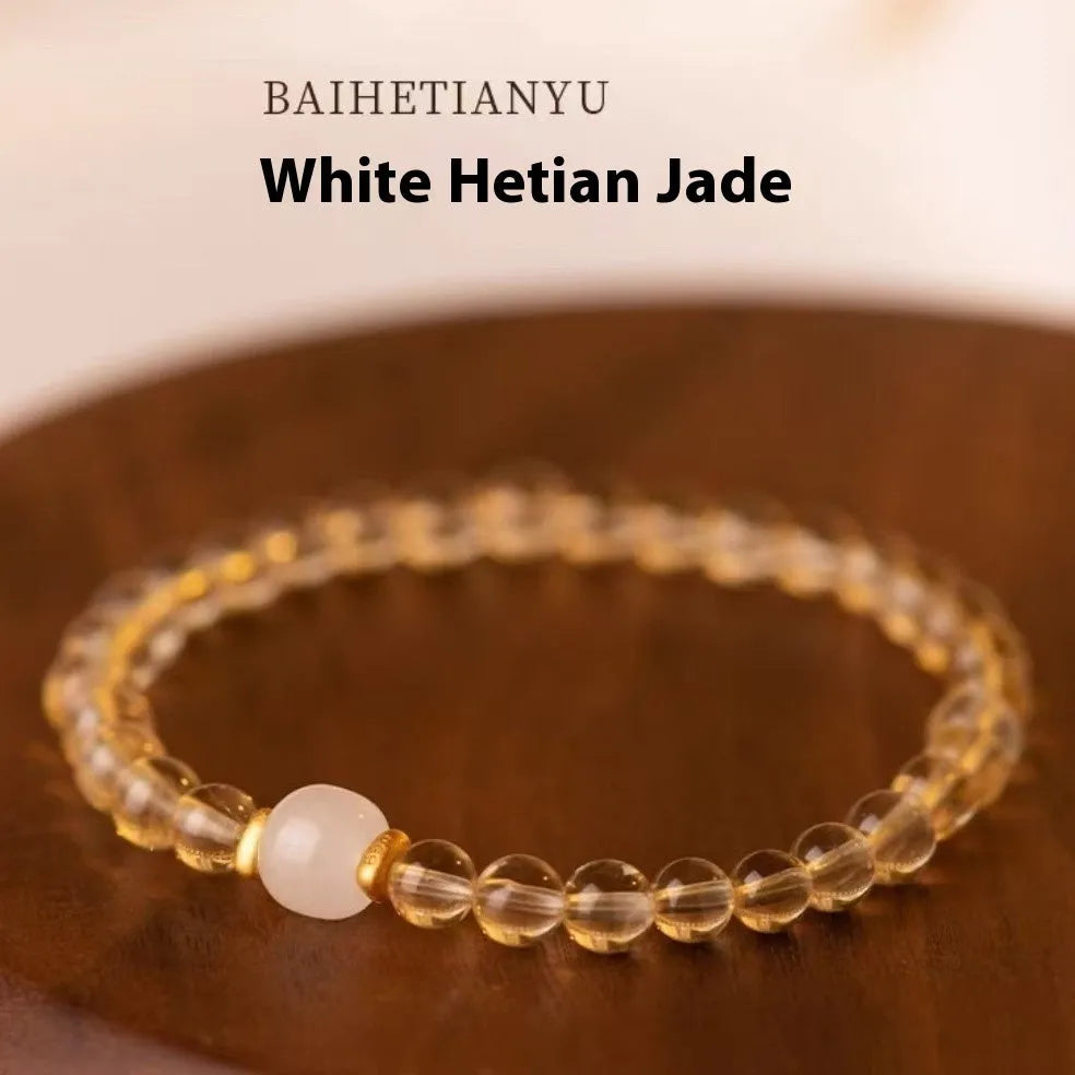 Close-up of a handmade adjustable bracelet made from natural rutilated quartz beads with golden rutile needle inclusions.