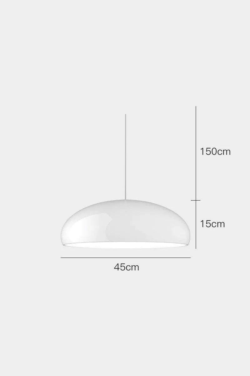 Danish-style iron pendant lamp with adjustable cord above a restaurant table.