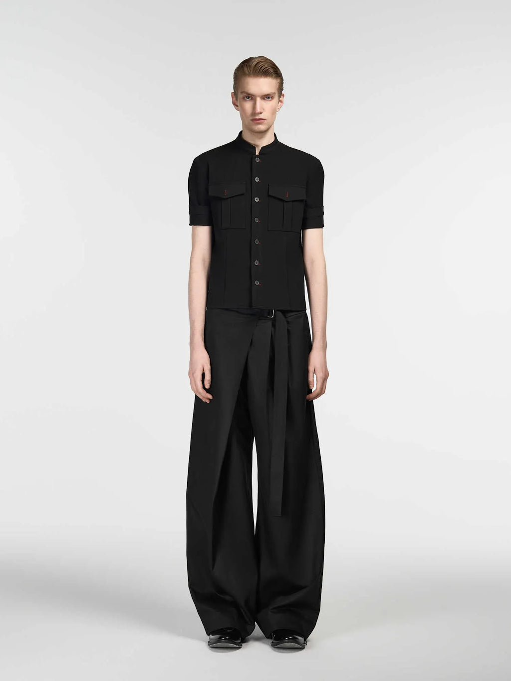 Black straight-leg trousers with a single pleat and adjustable waistband on a hanger.