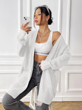Dark green women's loose-fit acrylic cardigan with two pockets and long sleeves.