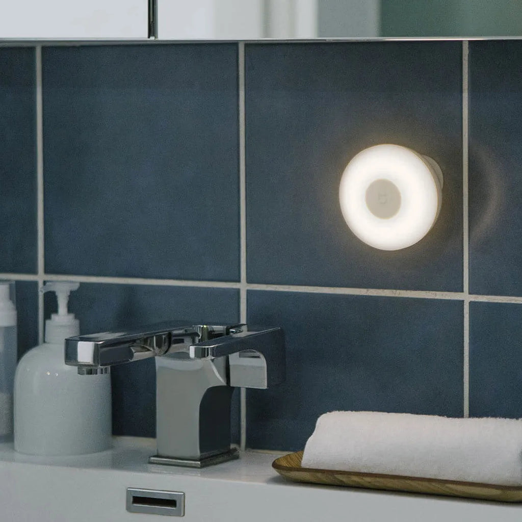 White Bluetooth induction bedside lamp with modern simple design on wooden nightstand