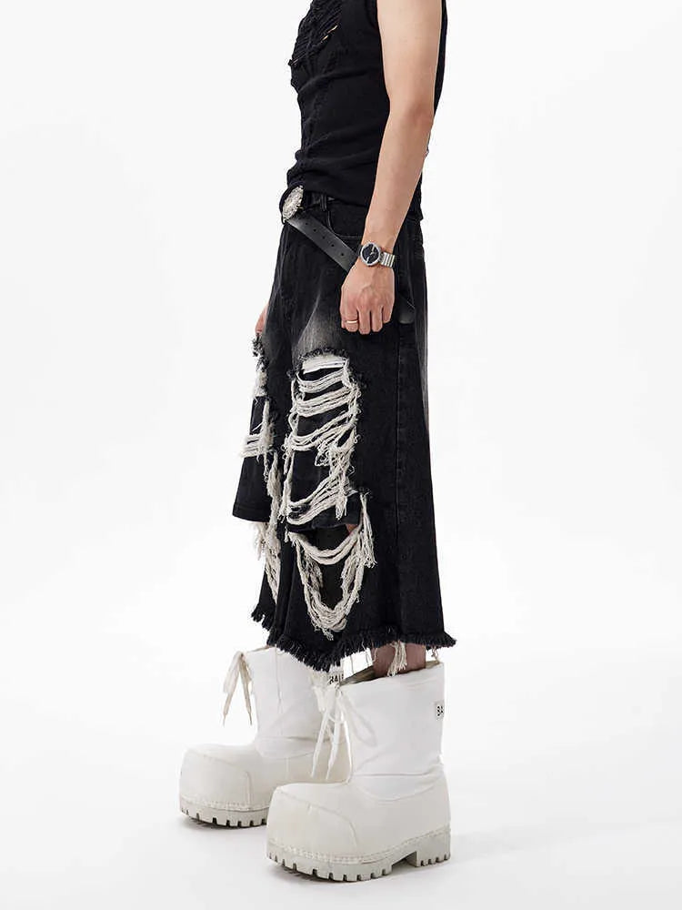 Model wearing black cropped wide-leg jeans with a distressed patch detail on the leg.