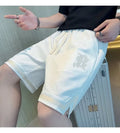Men's loose straight drawstring sports shorts in solid colour with wide leg and low waist on plain background