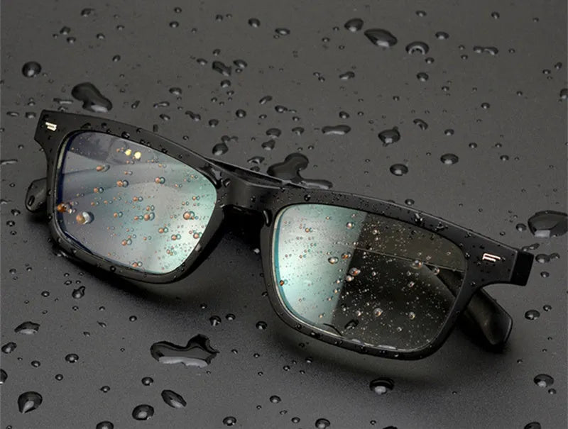 Smart sunglasses with open-ear Bluetooth speakers and polarised lenses on a table with charging case.