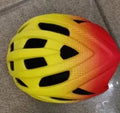 Orange lightweight bicycle helmet for road and mountain biking, showing ventilation holes.