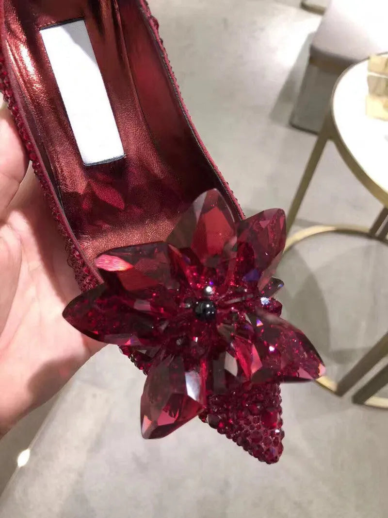 Women's gold stiletto high heel with pointed toe, rhinestone decorations, and a bow.
