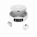 Mini Black and White semi-in-ear wireless headphones with their wireless charging case on a table.