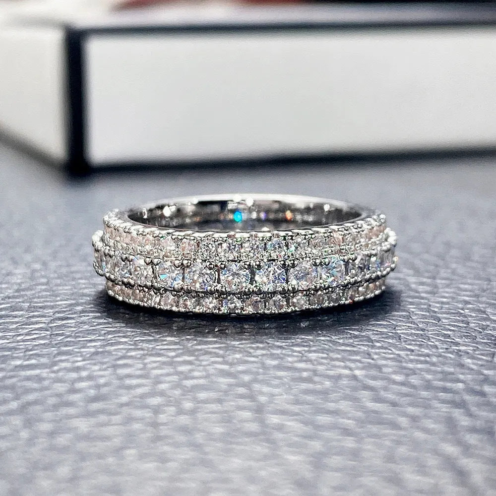 A geometric triangle-shaped ring with a zircon stone inlay, shown in a choice of metal colour finishes.